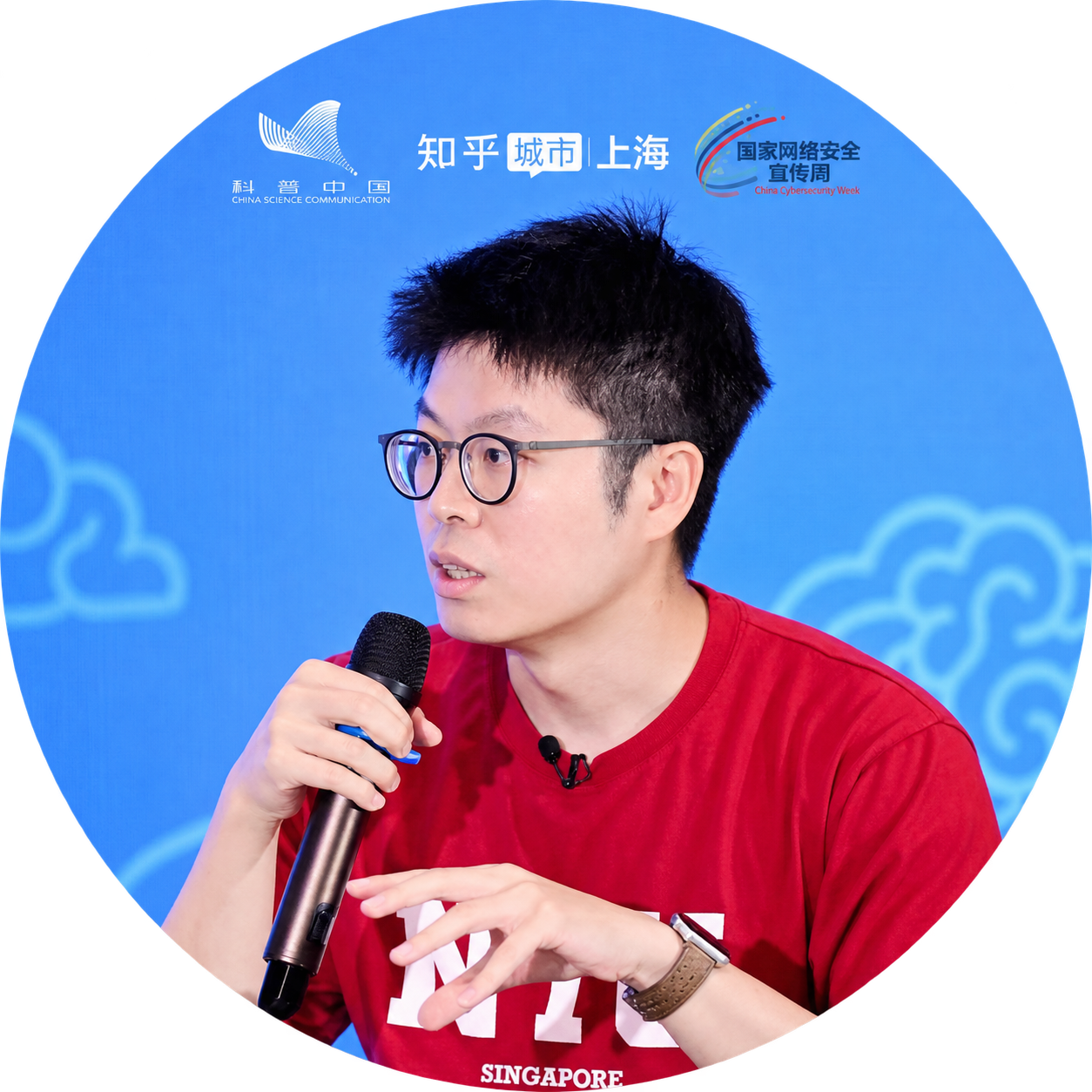 桔了个仔的合成圆形头像：戴眼镜、穿红色上衣持话筒发言，科普中国、知乎城市上海和国家网络安全宣传周标识融入同一画面顶部